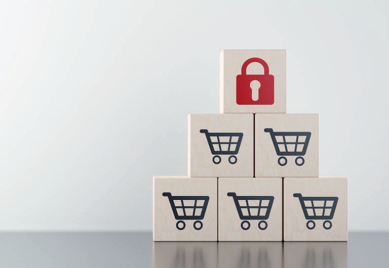 Five white cubes with a black shopping cart symbol printed on them with a sixth cube on top with a red padlock symbol on it, forming a pyramid