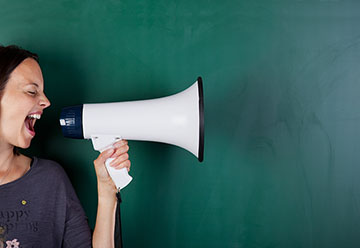 Woman with a megaphone in front of a green background