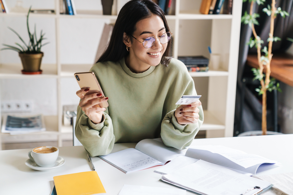 Girl shopping on mobile phone with credit card