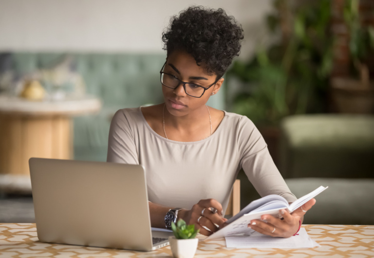 woman taking notes from her laptop 