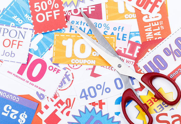 coupons and discount cards with a pair of scissors