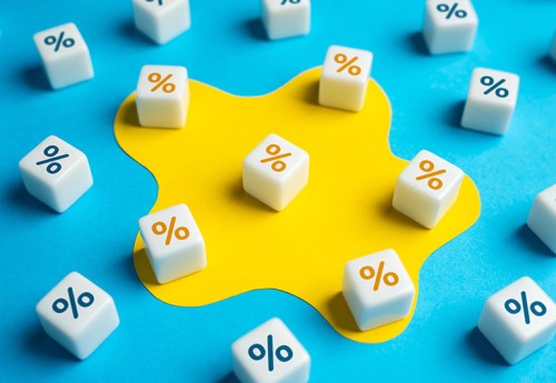 A dozen white die with orange and blue percentage symbols are scattered across a colourful board